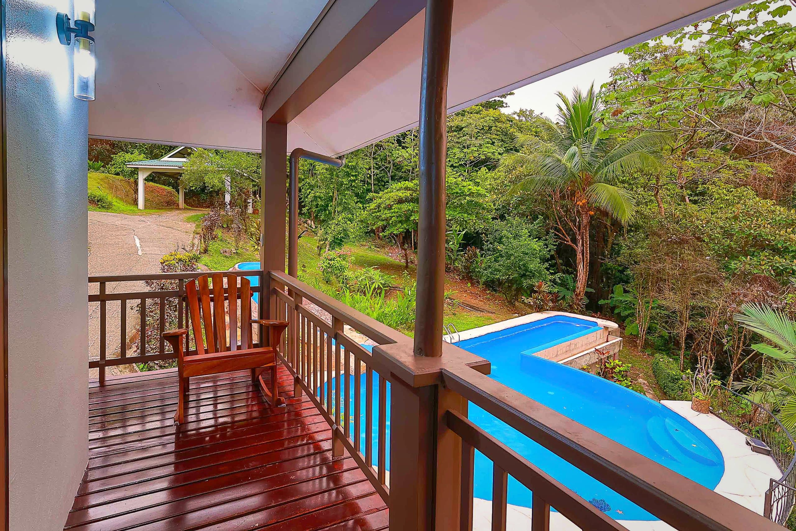 Balcón de madera con vista a la piscina y la selva